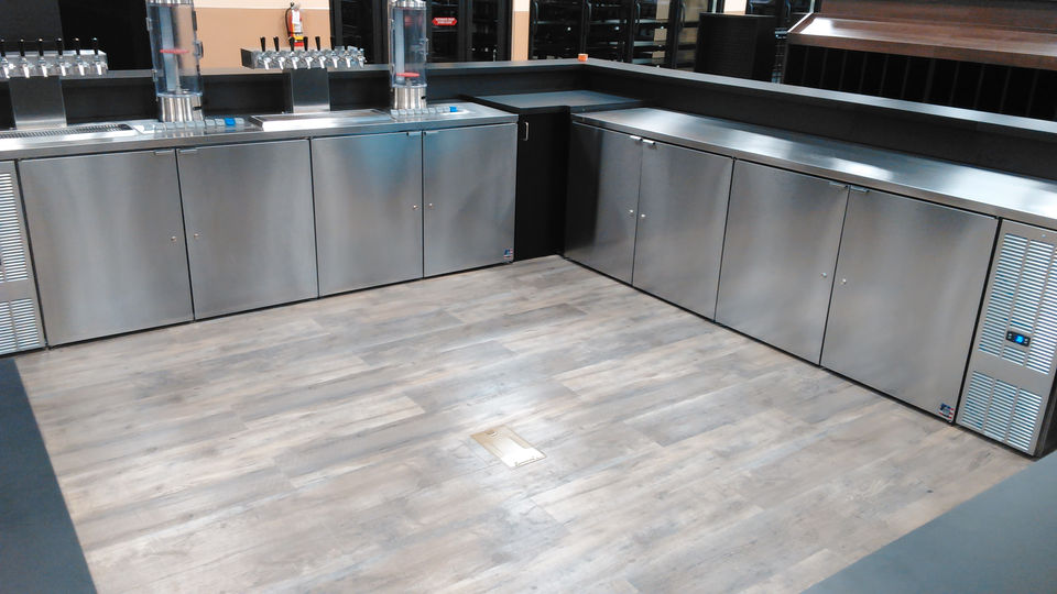 Stainless steel coolers and counters in a commercial bar area, cleaned and polished