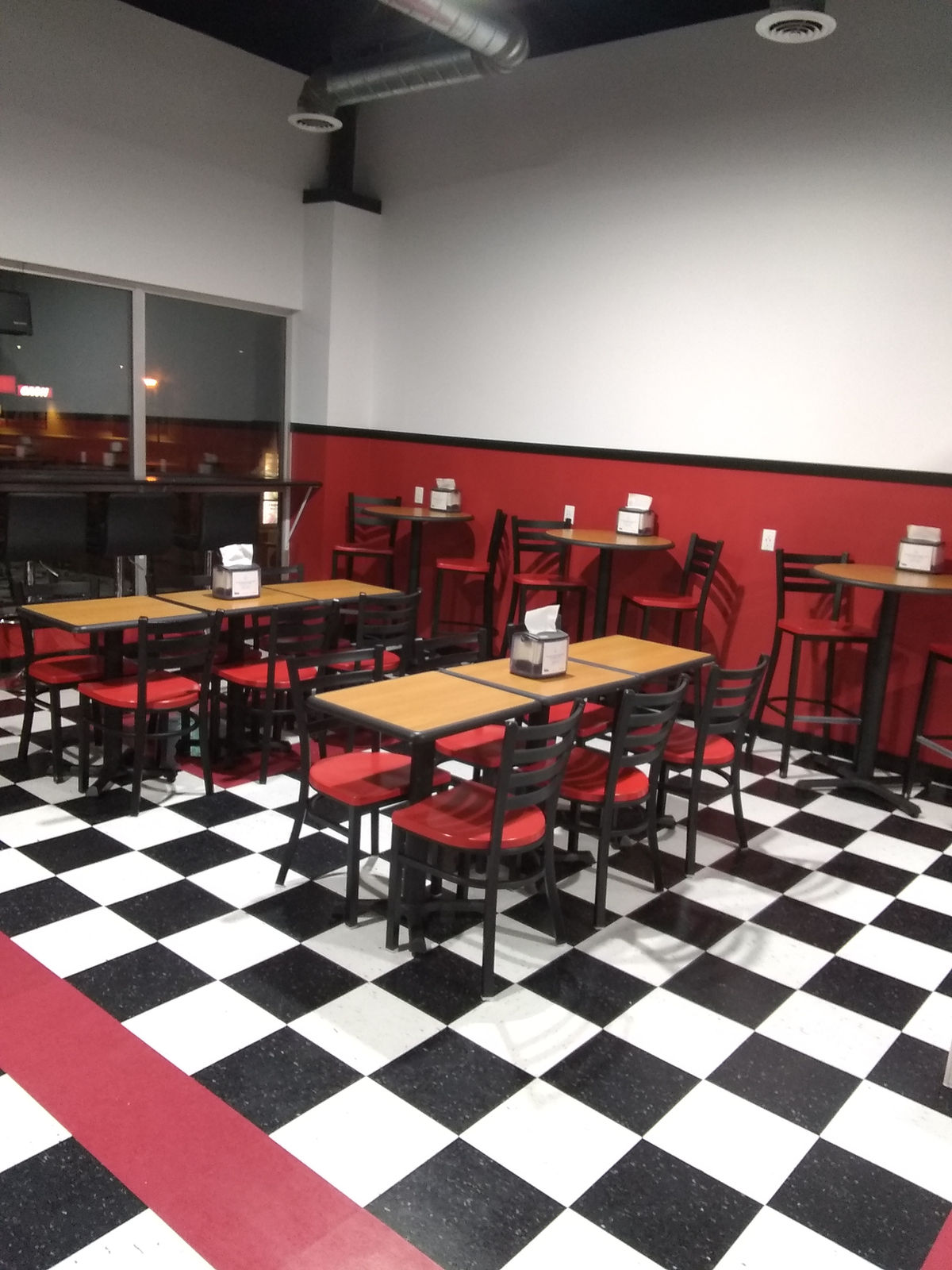 A restaurant dining area with checkerboard floor, tables and chairs cleaned and set